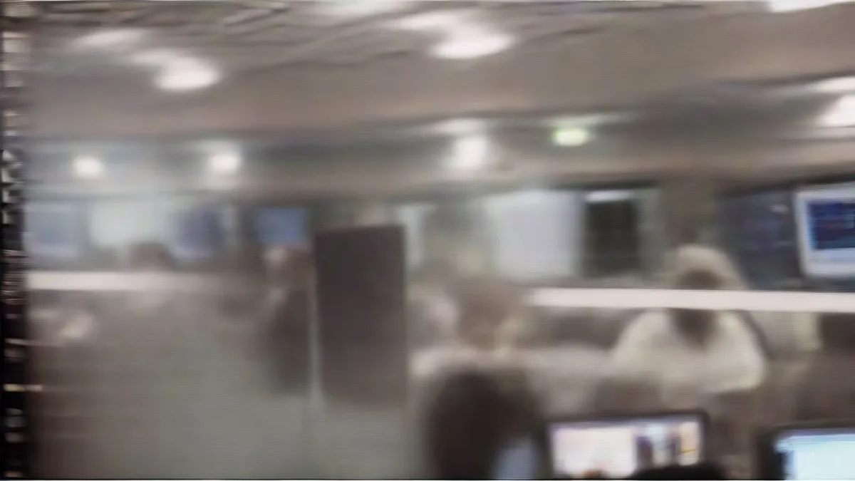 Traders sitting at computer desks on a bustling financial trading floor viewing market data