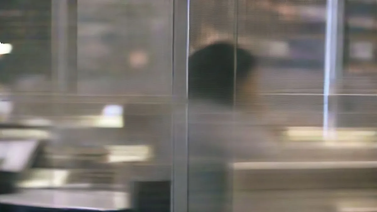 A financial trader sitting at a multi-monitor trading desk in a dimly lit office analyzing after-hours market movements.