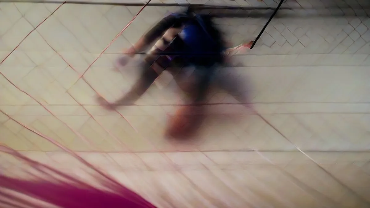 Anahat Singh in action lunging to return a shot on an indoor glass squash court during a tournament