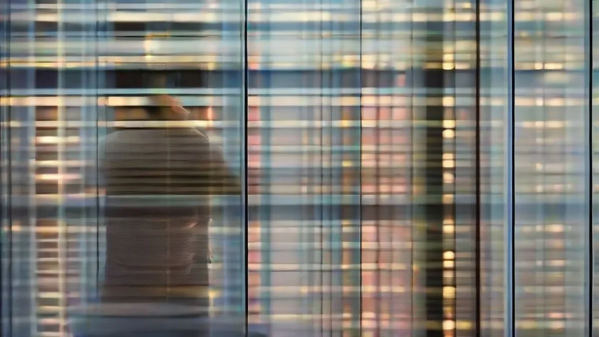 A technology professional working at a desk in a modern data center control room.