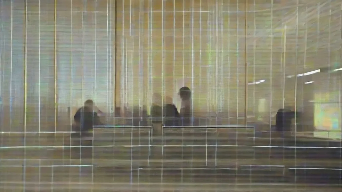 Engineers monitor network activity from consoles in a modern dimly lit corporate security operations center.