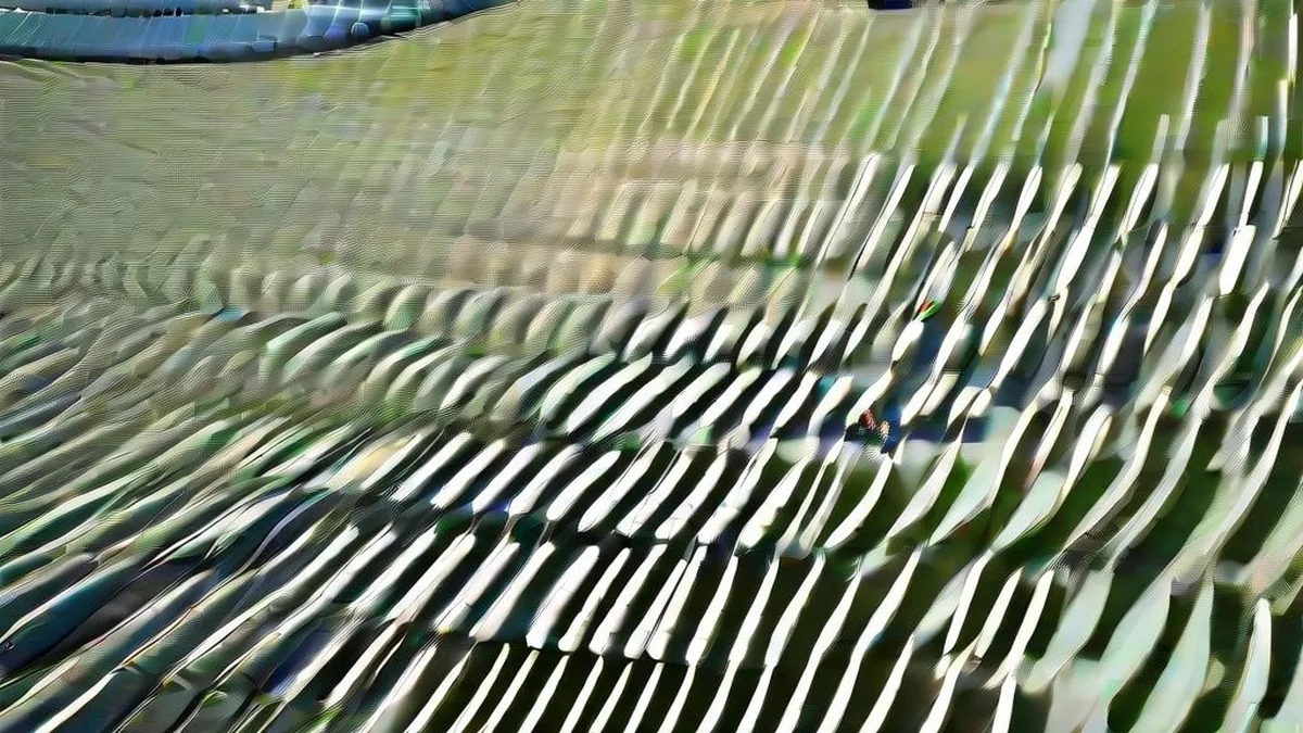 Wide angle view of an empty professional sports stadium grandstand and manicured green outfield in golden hour sunlight