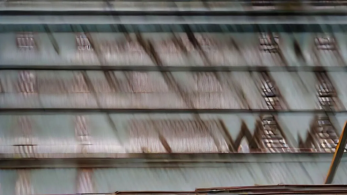 Stockpiles of industrial steel coils and beams at an open-air processing yard during early morning