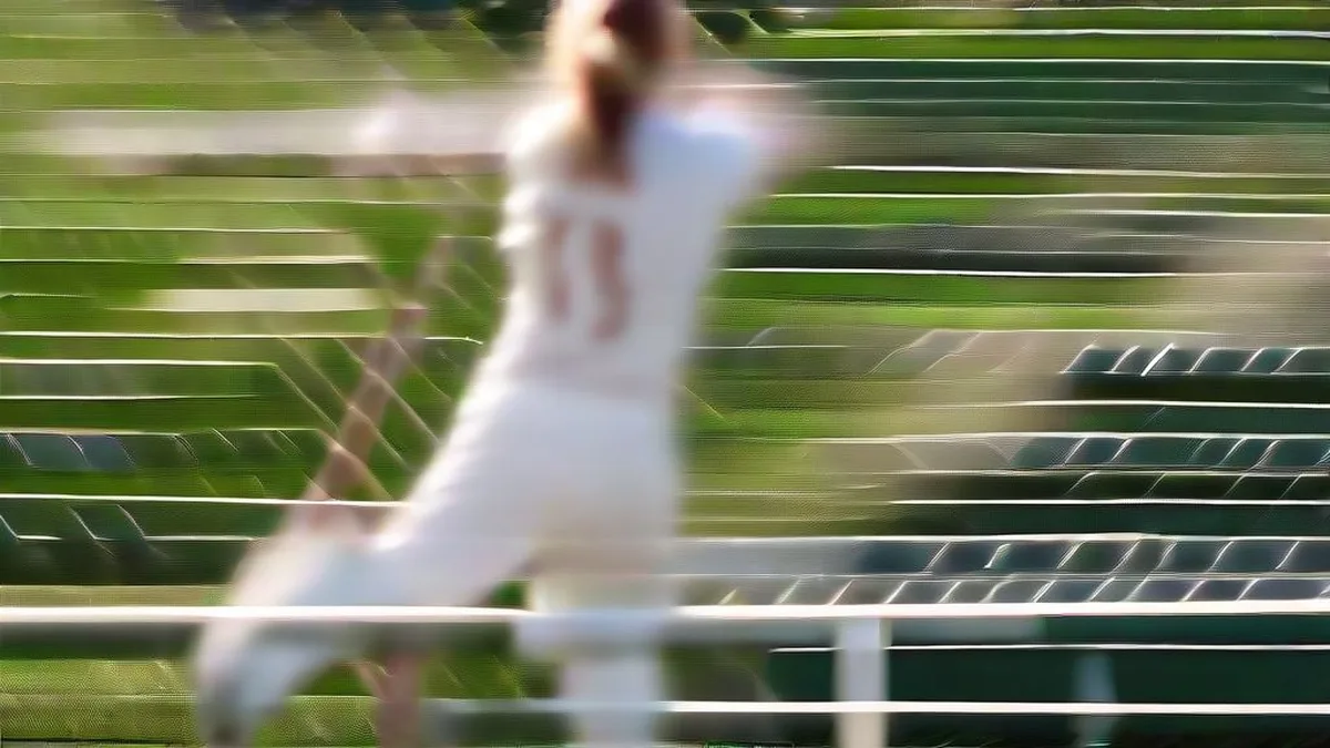 Female cricketer walking onto the field carrying a cricket bat in sunny stadium conditions