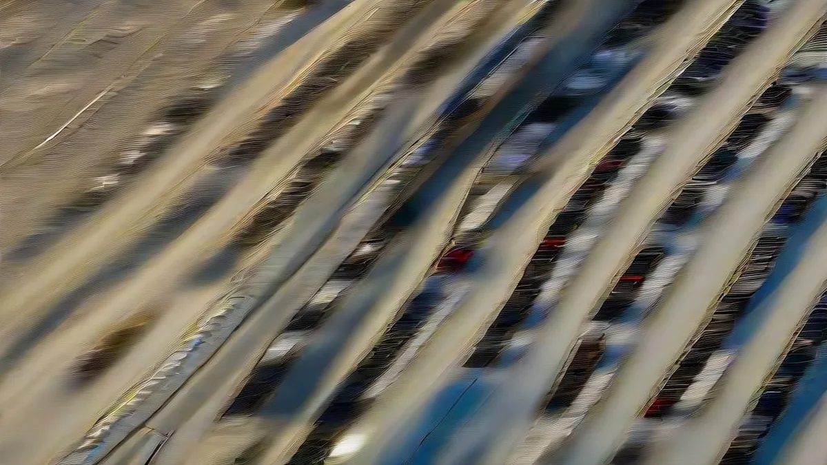 Rows of late-model passenger vehicles parked in neat alignment at an automotive fulfillment and inspection hub.