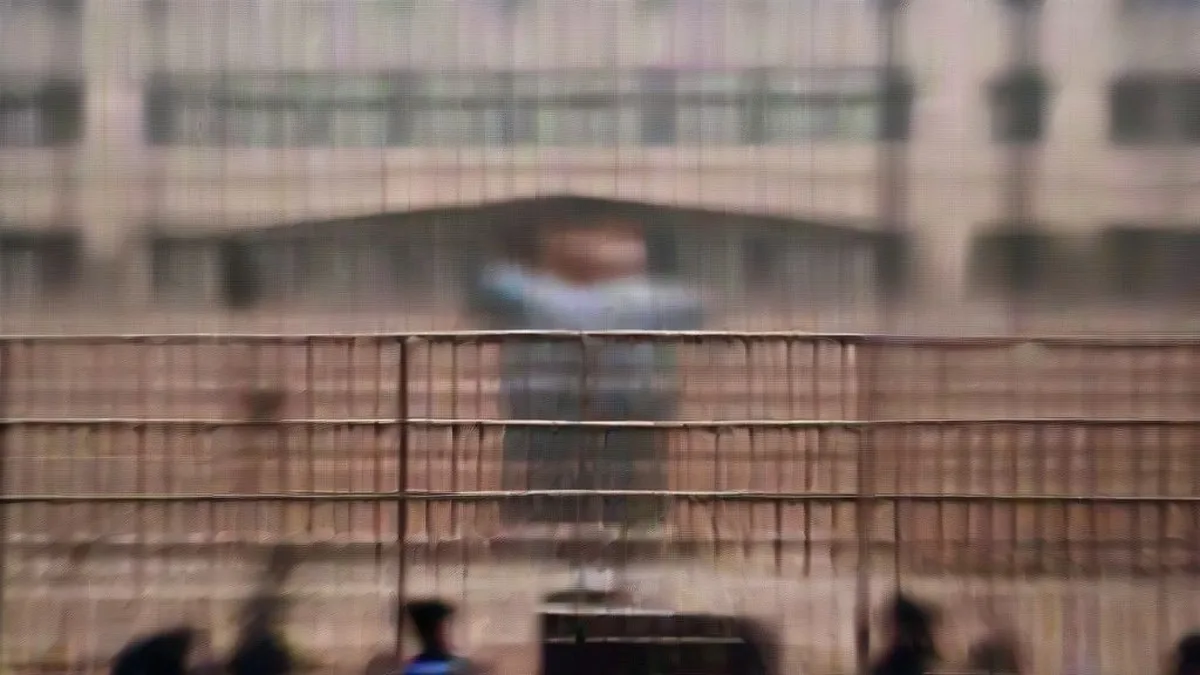 Student protesters and security personnel standing outside an institutional gateway in New Delhi