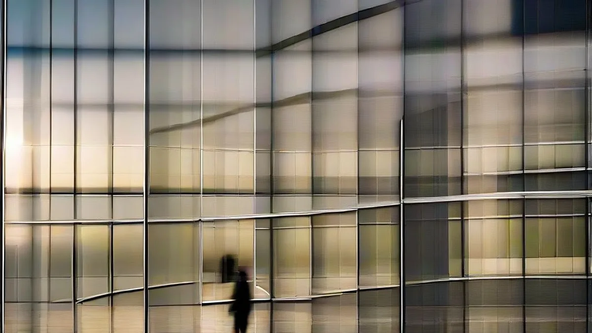 Professionals walking across a modern glass corporate technology office campus during late afternoon
