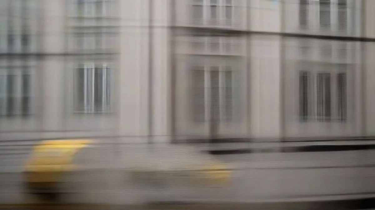 A delivery courier carrying insulated bags walking on a rain-slicked city sidewalk during dusk.