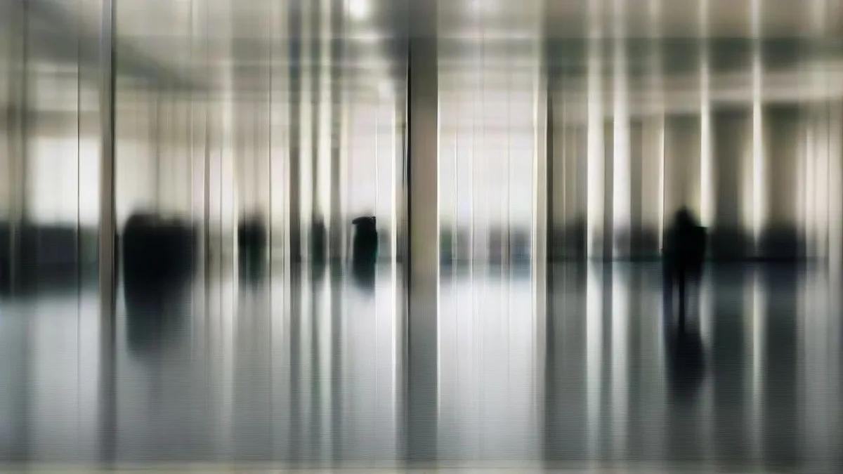 Financial corporate headquarters interior showing executive walking in glass-walled corporate environment