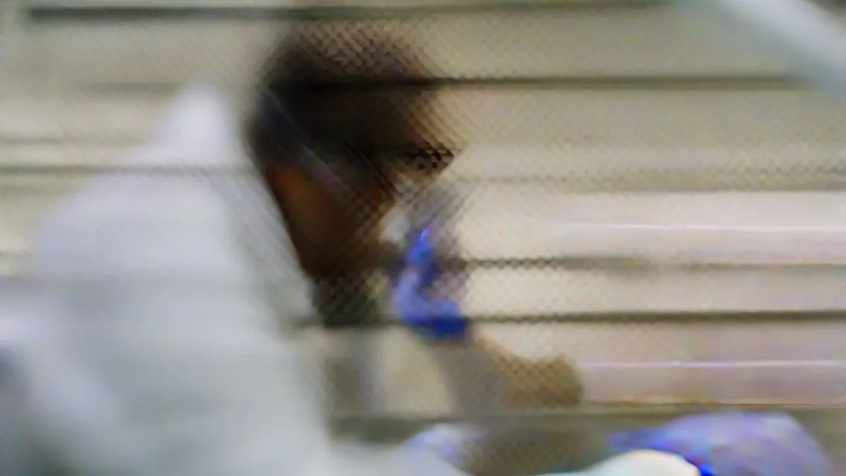 Laboratory researcher in white coat working with pharmaceutical compounds in a modern scientific lab