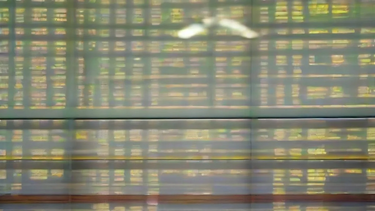 Financial traders working at trading desks surrounded by monitors displaying market activity