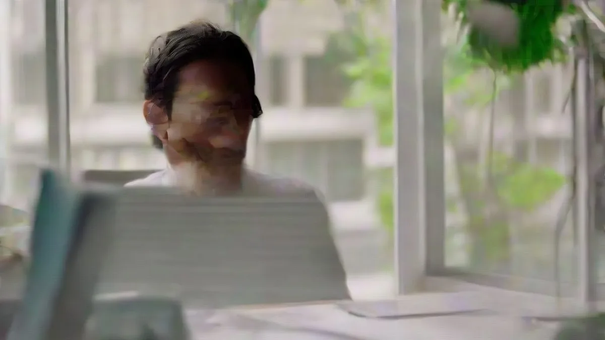 A software founder working at a desk in a sunlit tech startup office