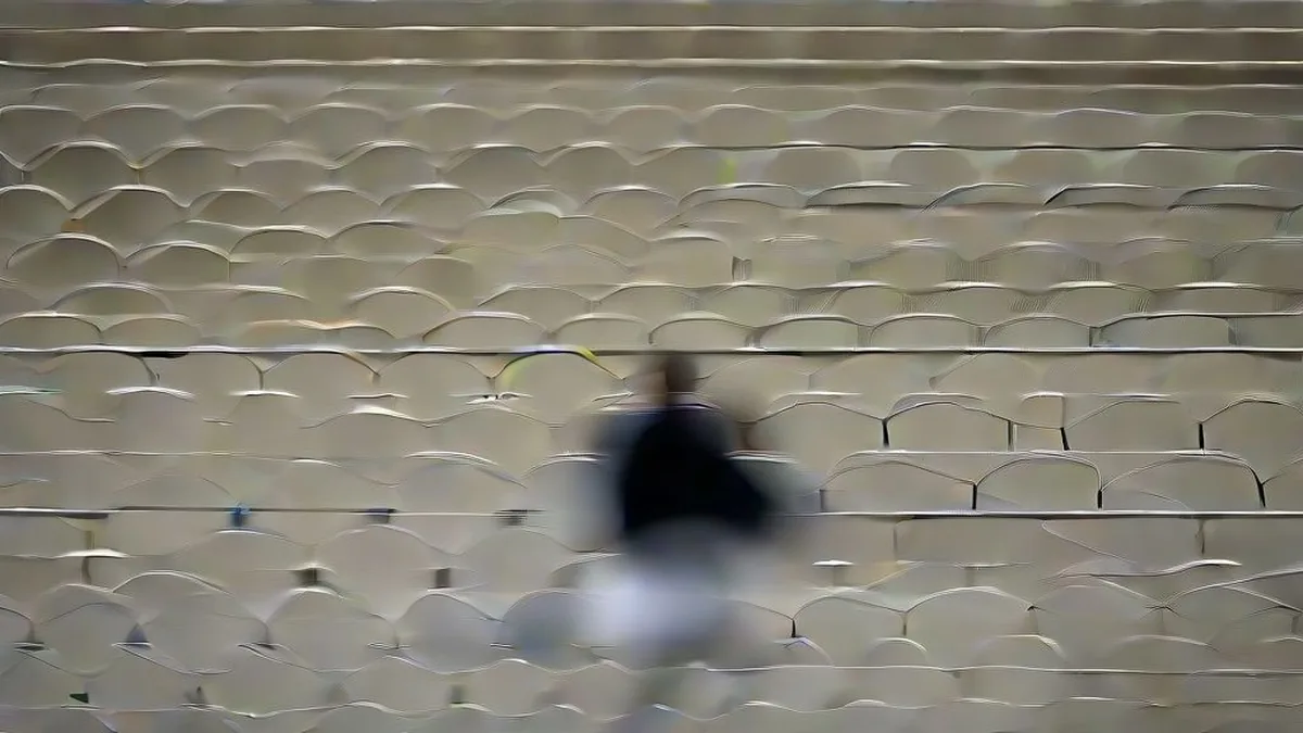 Cricket coach and bowler conducting a practice session at an international stadium during training