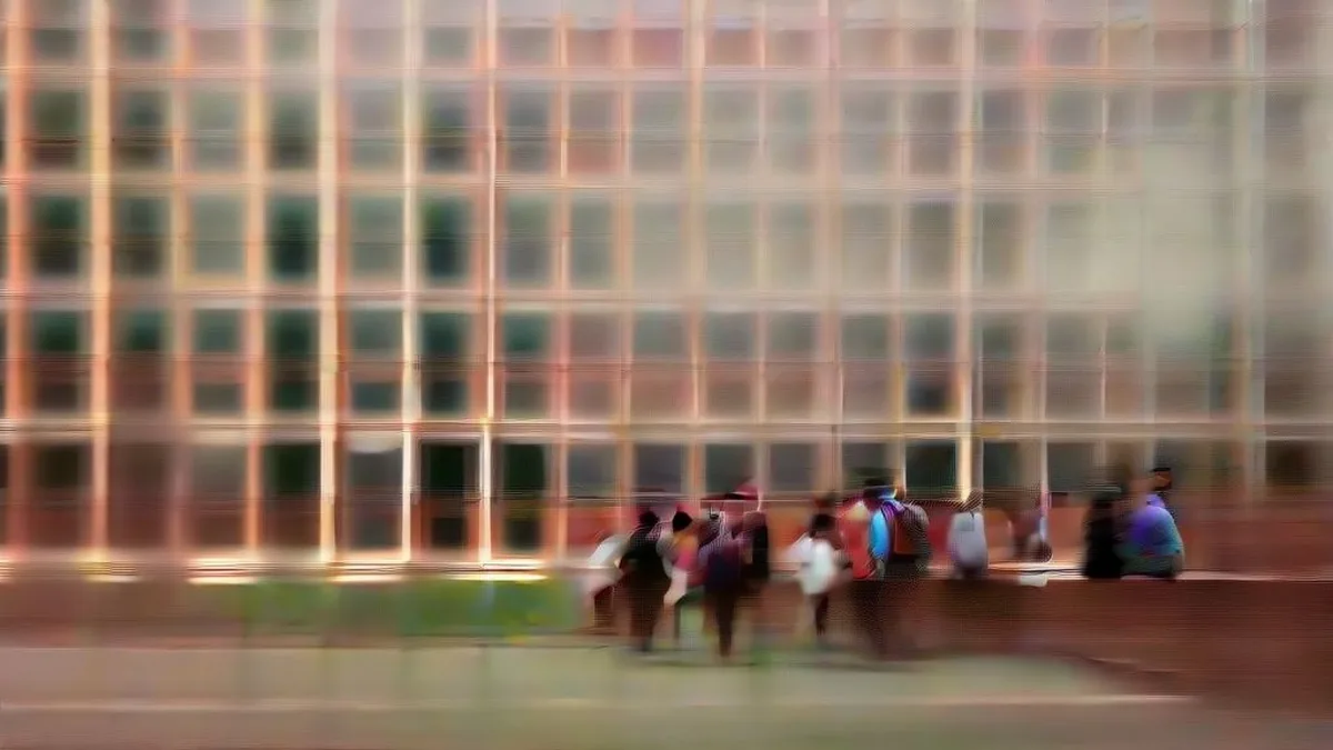 Students gathered on a university campus pathway outside academic buildings