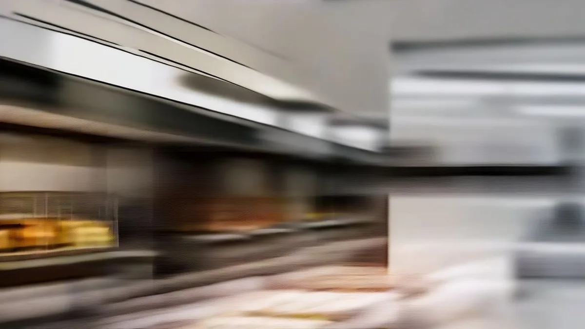 Stainless steel commercial deli prep counter with fresh ingredients in a fast-casual restaurant