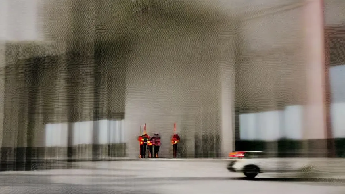 Administrative government complex with police security and vehicles parked outside during an ongoing official inquiry.