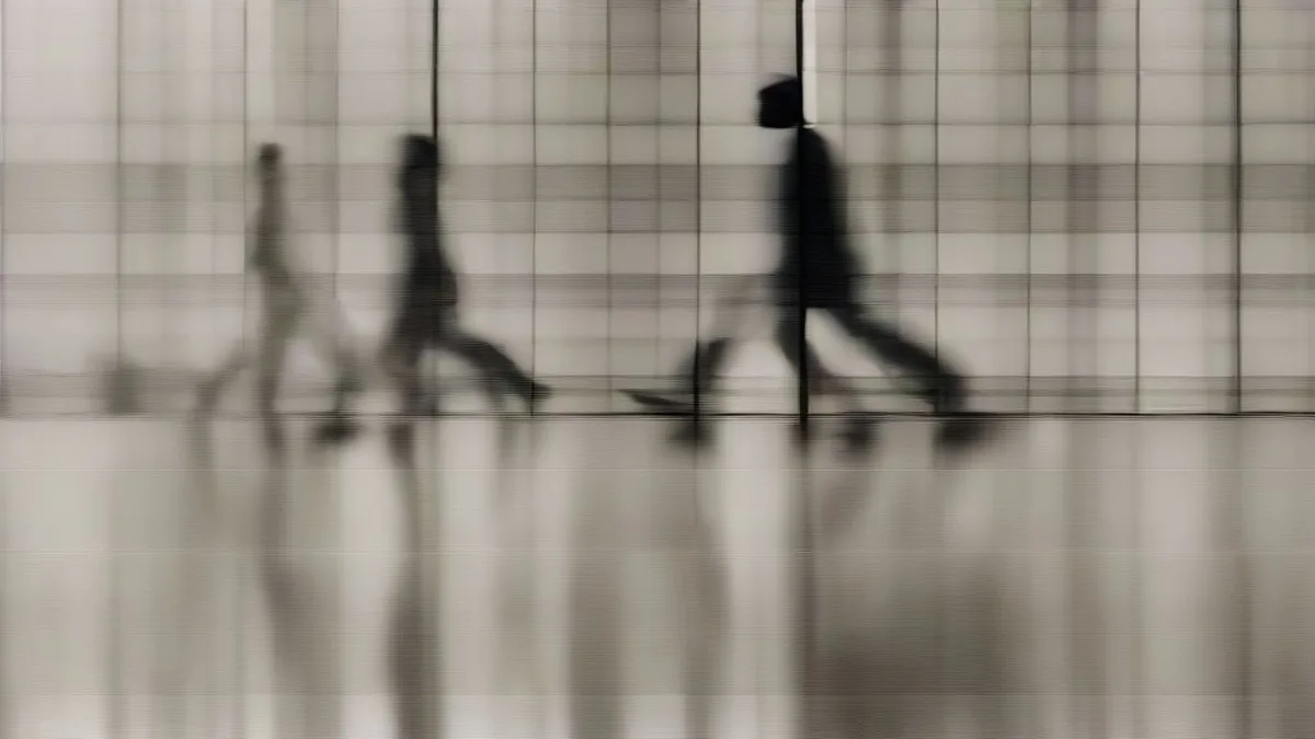 Attorneys and executives walking through the modern glass-and-marble atrium of a corporate office tower
