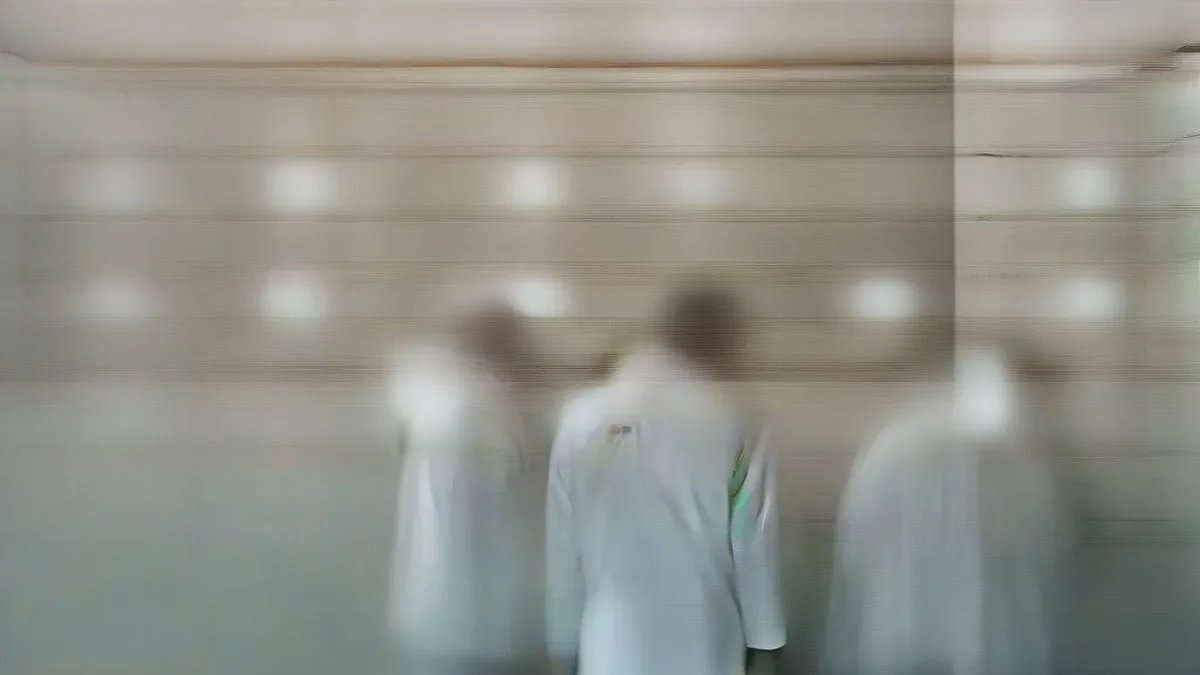 Corridor of a hospital emergency department showing medical staff and police personnel standing in the background