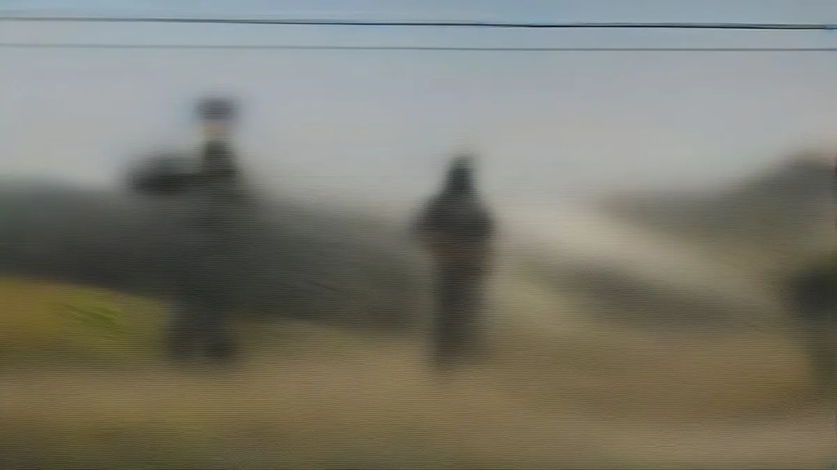 Security personnel standing guard on an empty highway in a hilly landscape