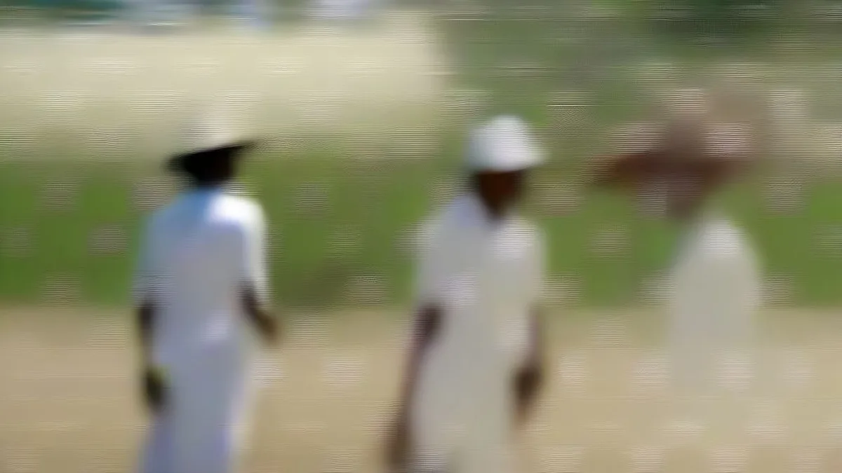 Cricket players standing on a grass outfield reacting to a disruption during an Under-19 match