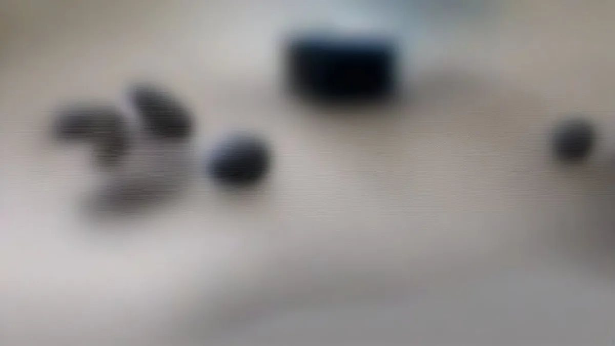 Wireless earbuds resting on a minimalist surface in an audio testing environment
