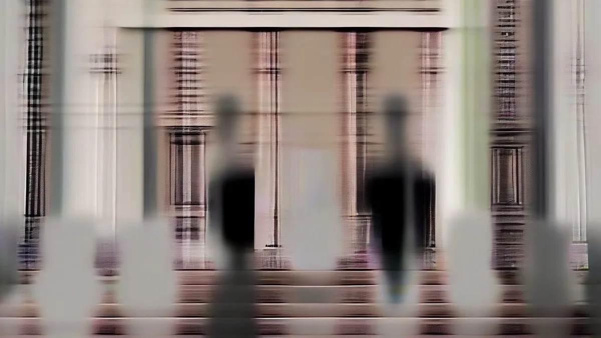 Exterior view of high court building with police officers and advocates walking near columns