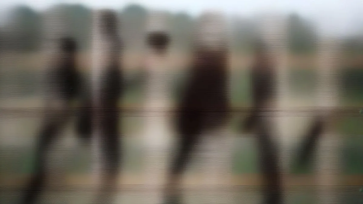 Police officers standing guard behind barricades along a rural Punjab road amid local protests