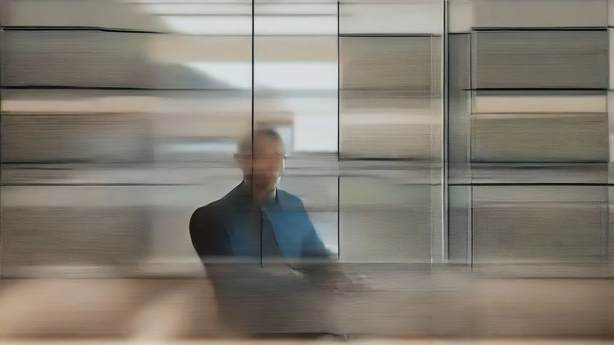 A financial professional examining operational metrics on computer monitors in an office setting.