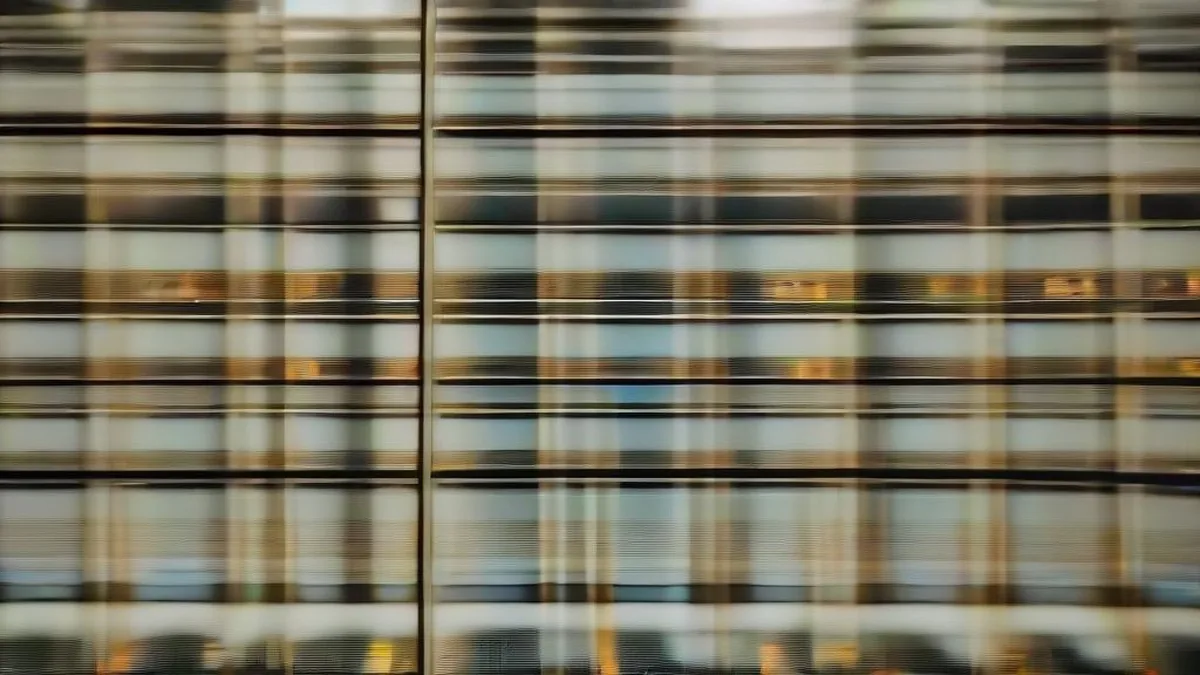 Stock market trader reviewing multiple glowing screens on a modern corporate financial trading floor.