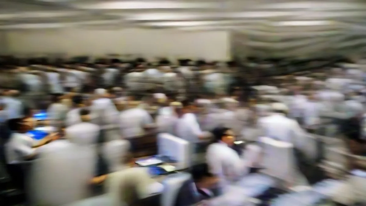 Traders working on multi-screen terminals on an active financial dealing floor during a market rally.