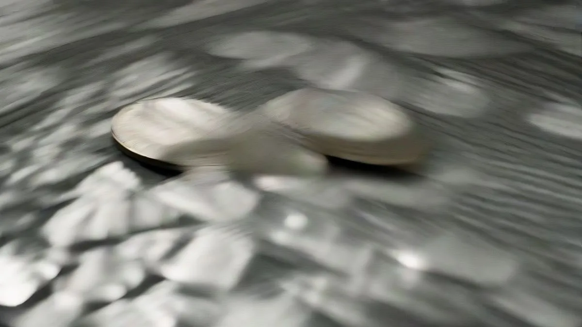 Polished silver bullion ingots resting on a dark velvet surface in a vault.