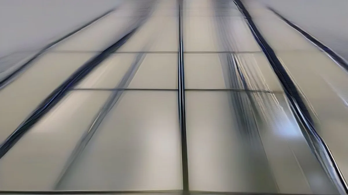 Semiconductor cleanroom technician working among wafer processing machinery under sterile laboratory lighting