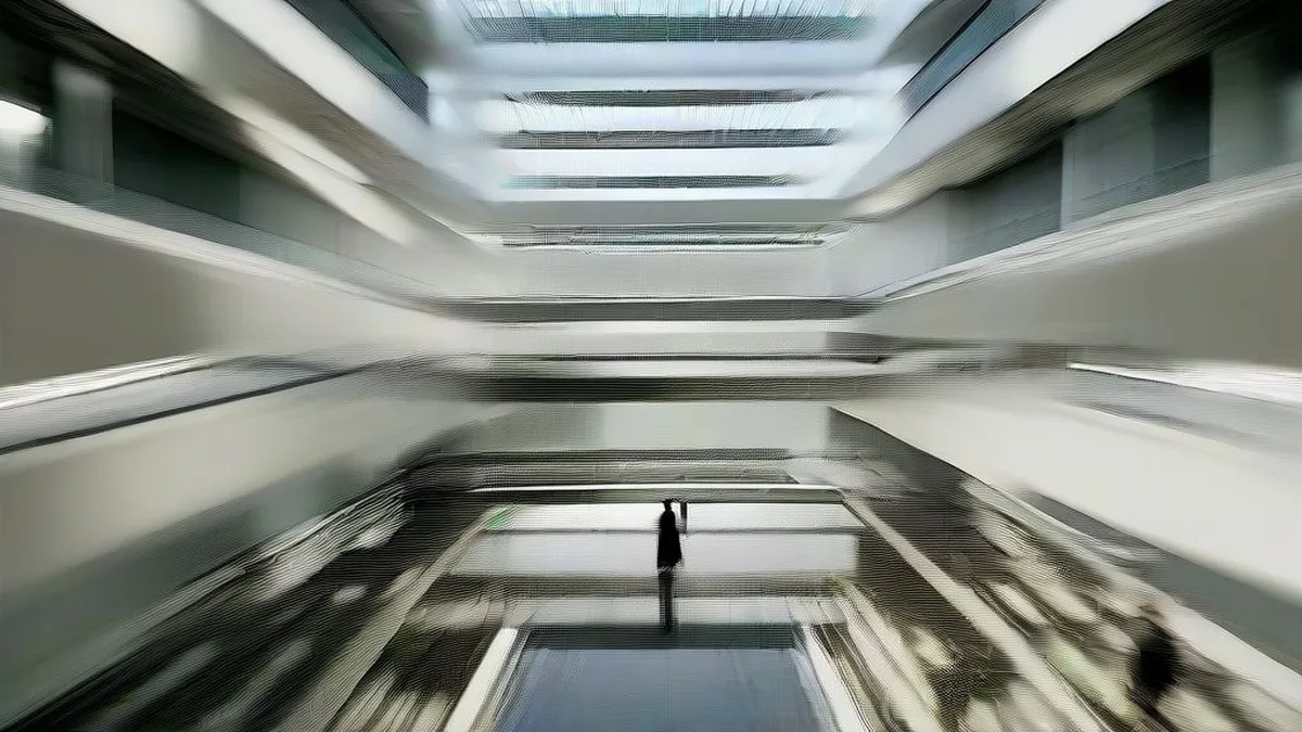 A corporate media office campus with professionals walking through an open glass atrium