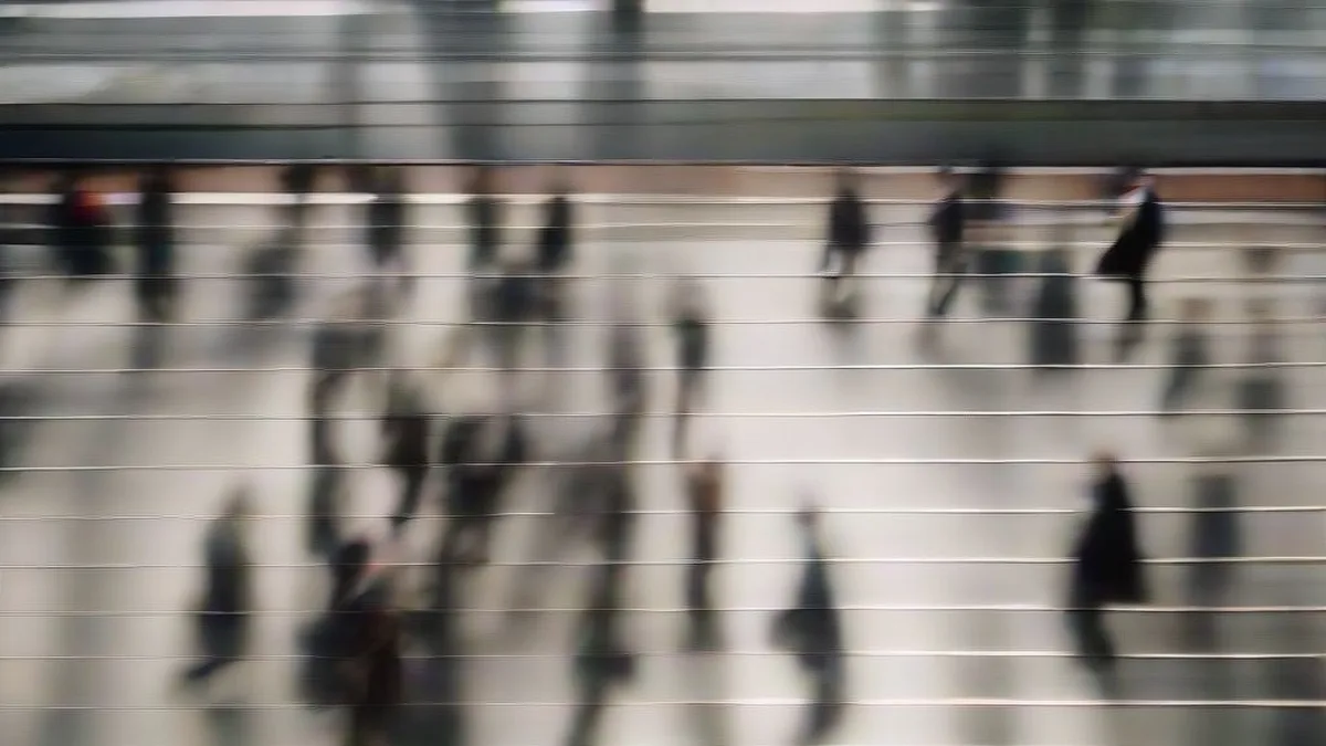 Professionals walking across a city street in a financial district during morning daylight