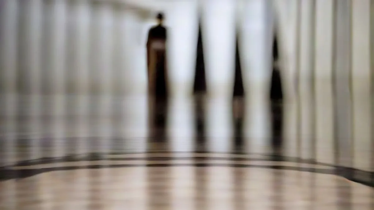 A senior lawmaker walks through the ornate marble halls of the United States Capitol flanked by aides and journalists.