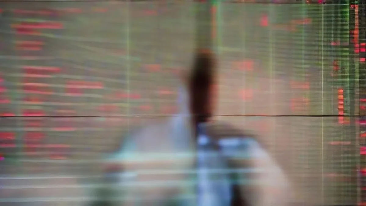 Financial trader analyzing market data on trading floor monitors