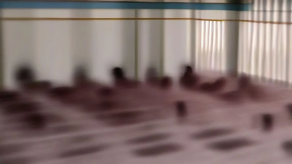 Schoolchildren in uniform sitting on woven floor mats inside a rural Indian classroom