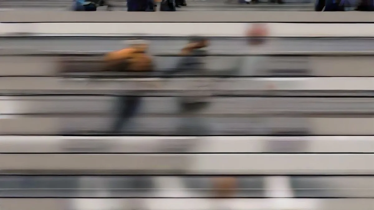 Pedestrians carrying shopping bags in an outdoor commercial district under soft daylight