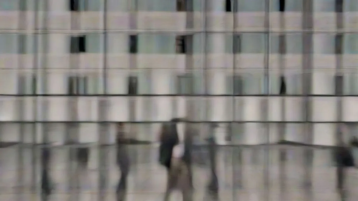 Exterior view of diplomats outside the United Nations headquarters building under an overcast sky.
