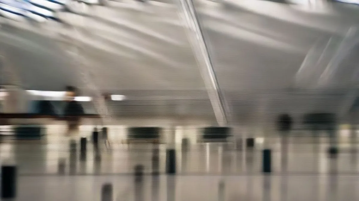International airport arrivals concourse with travelers and airport security personnel