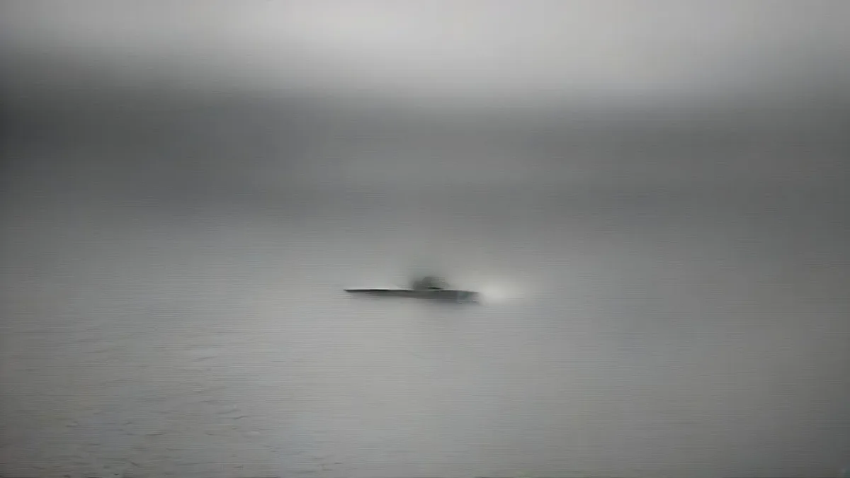 Naval patrol vessel cutting through open ocean waters during twilight