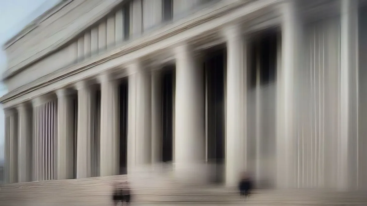 Exterior view of the neoclassical U.S. Treasury building in Washington D.C. under an overcast sky.
