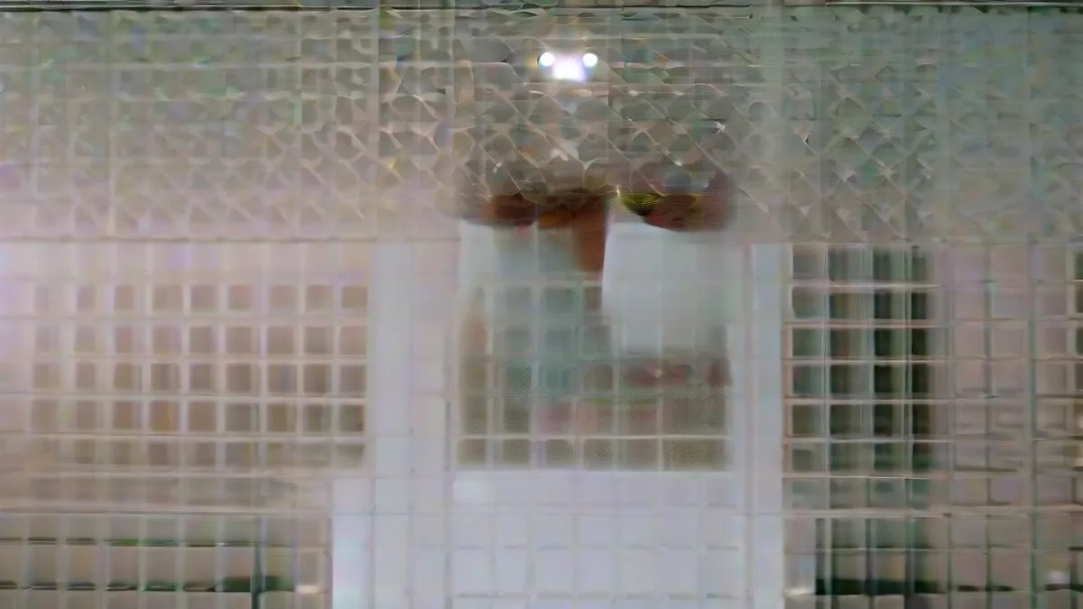 Semiconductor manufacturing technician inspecting a silicon wafer in a sterile cleanroom facility